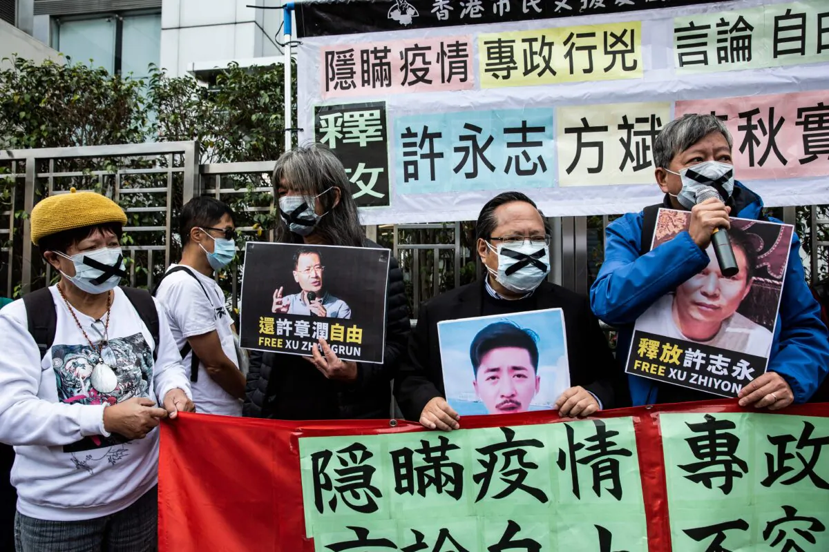 Pro-democracy protesters from HK Alliance hold placards of detained rights activists outside the Chinese liaison office in Hong Kong on February 19, 2020. (Isaac Lawrence/AFP via Getty Images)