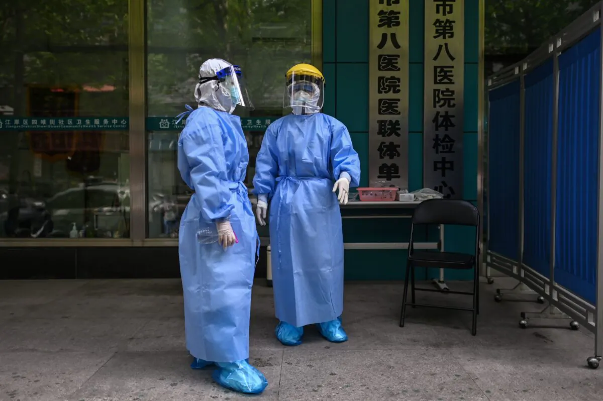 Medical workers are seen as they take swab samples from people to be tested for the COVID-19 novel coronavirus in Wuhan, China's central Hubei province on April 16, 2020. (Hector Retamal/AFP via Getty Images)