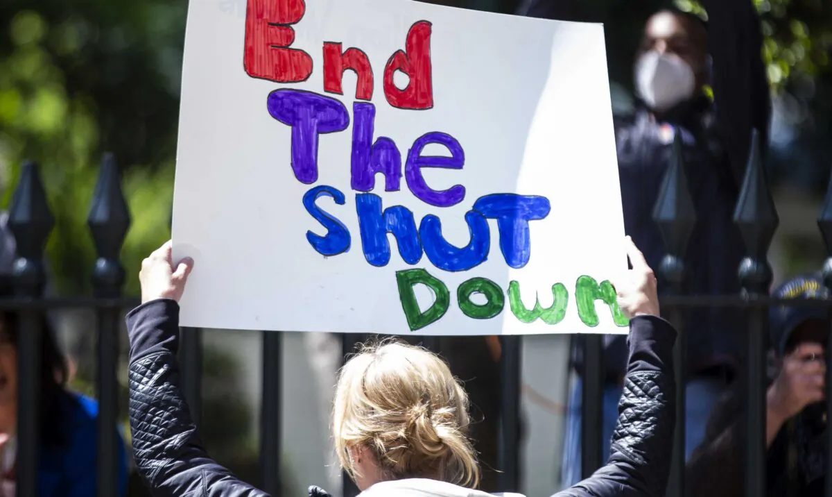 A demonstrator holds a sign at the Virginia State Capitol in Richmond on April 16, 2020. (Zach Gibson/Getty Images)