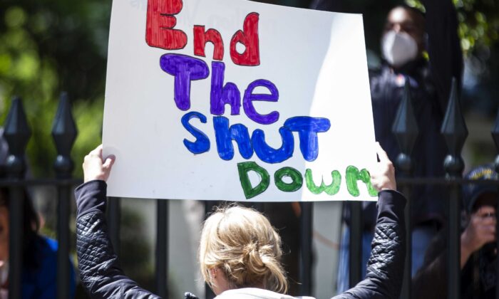 A demonstrator holds a sign at the Virginia State Capitol in Richmond on April 16, 2020. (Zach Gibson/Getty Images)