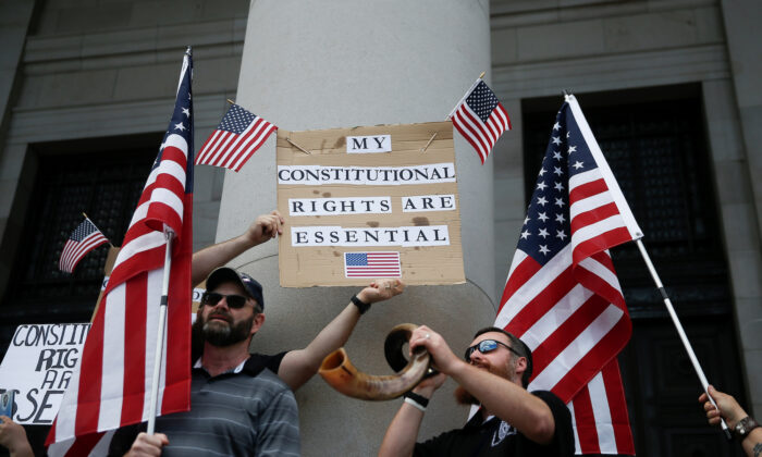 Demonstrators protest against an extended stay-at-home order to help slow the spread of COVID-19 at the Capitol building in Olympia, Washington, on April 19, 2020. (Reuters/Lindsey Wasson)