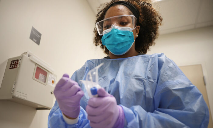 Velocity Urgent Care x-ray technician and medical assistant Britni Chavis prepares to test a patient for the novel coronavirus in Woodbridge, Va., April 15, 2020. (Chip Somodevilla/Getty Images)