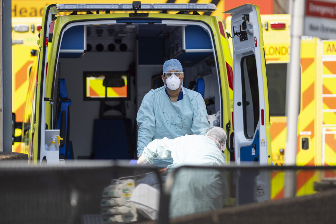 Health workers in PPE take a patient from an ambulance in London, UK, on April 10, 2020. (Justin Setterfield/Getty Images)