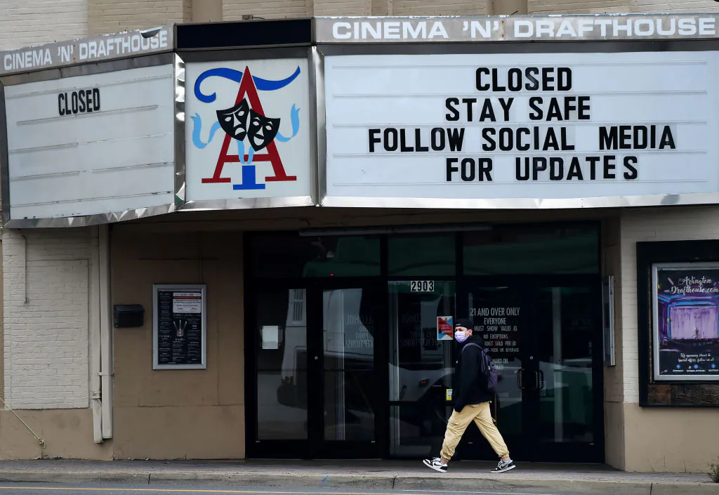 A man wearing a face mask to protect himself from the coronavirus walks past a closed theater in Arlington, Virginia on April 18, 2020. ( Olivier Douliery/AFP via Getty Images)