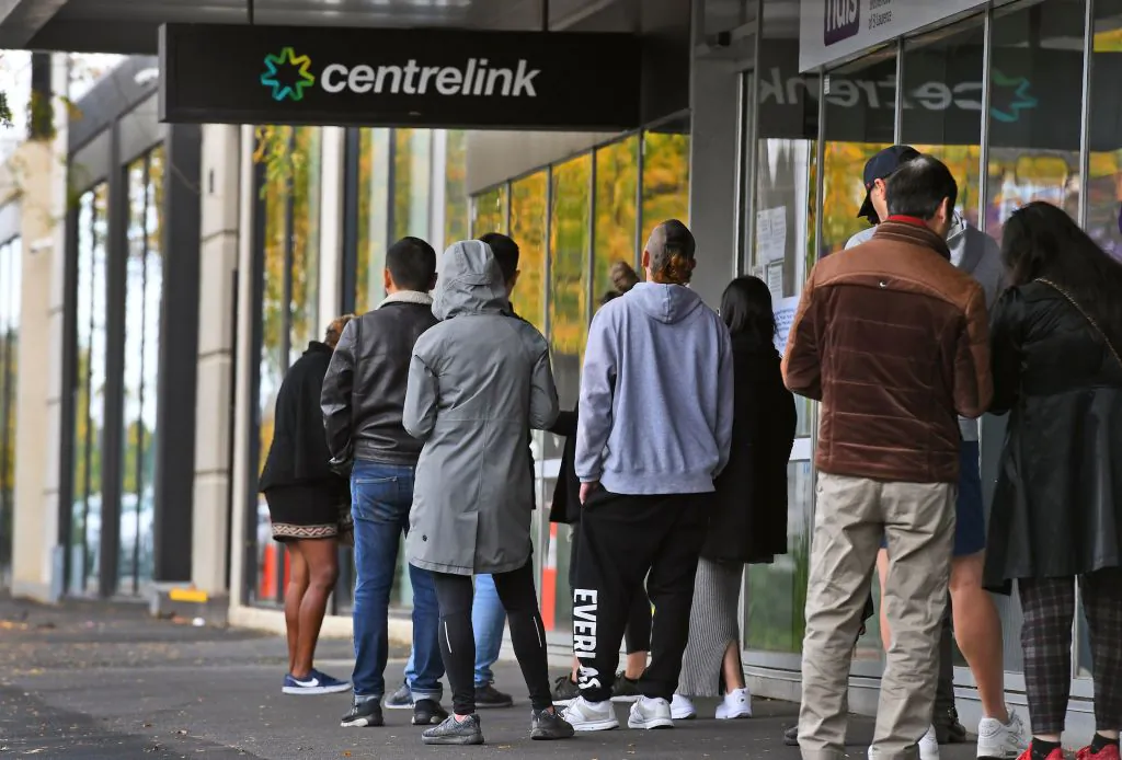 People queue up outside a Centrelink office for government payments in Melbourne on April 20, 2020. (William West/AFP via Getty Images ) 