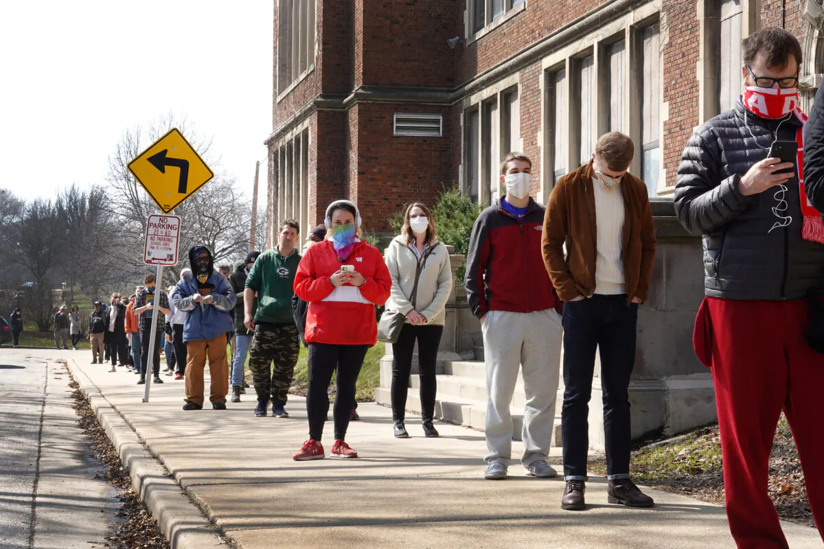 Voters wait in line to enter a polling place at Riverside University High School in Milwaukee, Wis., on April 07, 2020. (Scott Olson/Getty Images)