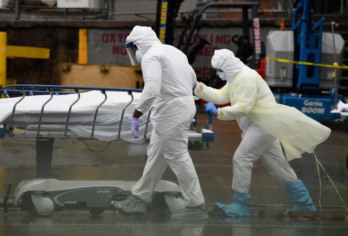 Medical personnel move a deceased patient to a refrigerated truck serving as a makeshift morgue at Brooklyn Hospital Center in New York City, on April 9, 2020. (Angela Weiss/AFP/Getty Images) 