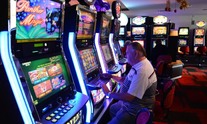 A retiree playing electronic poker machines at the Randwick Labor Club in Sydney, Australia, on Dec. 21, 2012. (William West/Getty Images)