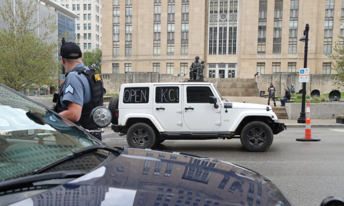 Protesters drive past City Hall encouraging people to demand that businesses be allowed to open up, and people allowed to go back to work, in Kansas City, Mo., on April 20, 2020. (Jamie Squire/Getty Images)