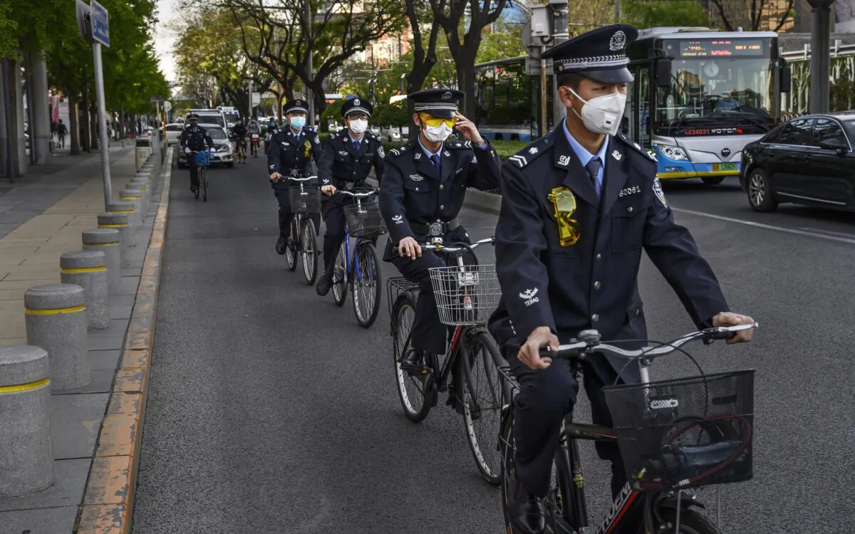 Chinese officers ride in together on bicycles in a shopping area in Beijing, China, on April 22, 2020. (Kevin Frayer/Getty Images)