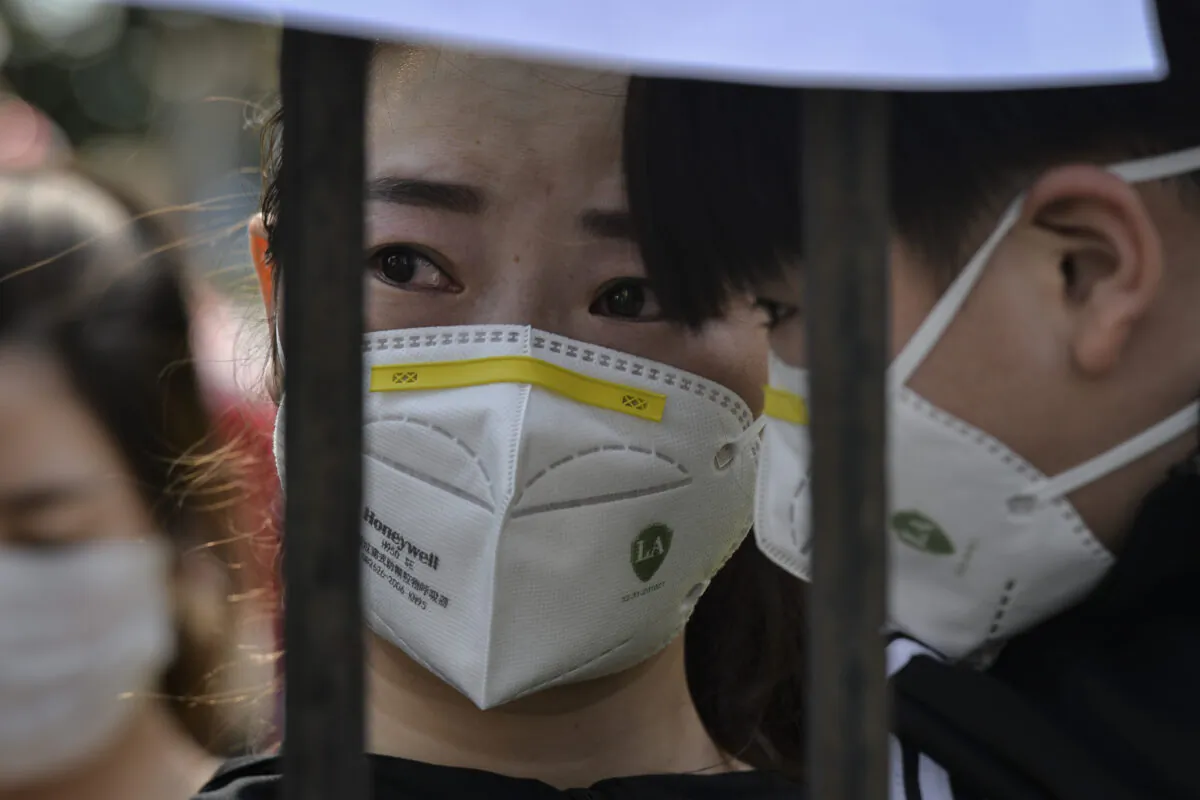 A Wuhan resident reacts as a medical assistance team from Yunnan province depart after helping with the COVID-19 coronavirus recovery effort in Wuhan, China, on March 18, 2020. (AFP via Getty Images)