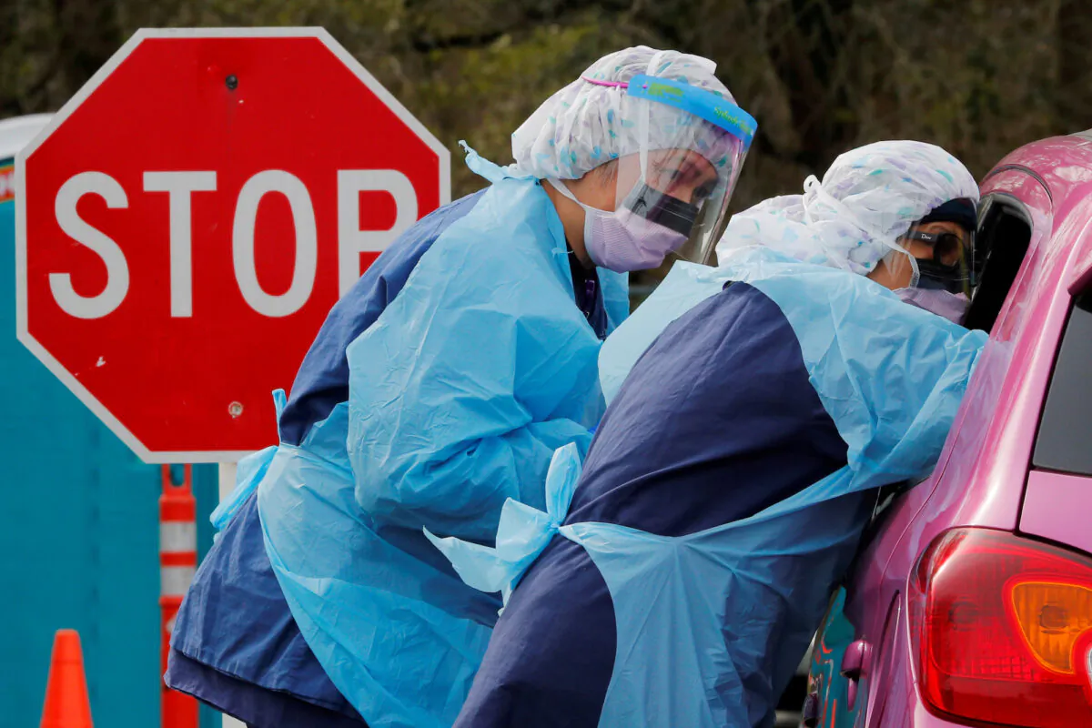 Nurses administer a COVID-19 test at a drive-through testing site in Seattle on March 17, 2020. (Brian Snyder/Reuters)