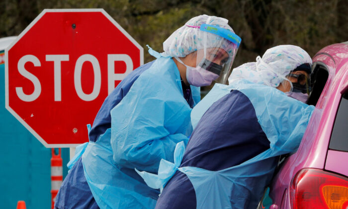 Nurses administer a COVID-19 test at a drive-through testing site in Seattle, Washington, on March 17, 2020. (Brian Snyder/Reuters)