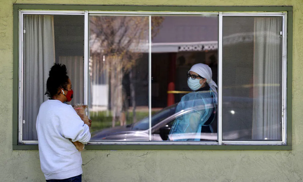 A visitor talks with a nurse through a window at the Gateway Care and Rehabilitation Center in Hayward, Calif., on April 14, 2020. (Justin Sullivan/Getty Images)