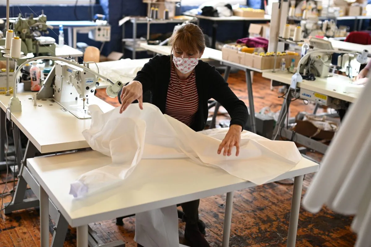 A machinist sews a surgical gown at shirtmaker McNair, during the nationwide lockdown in northern England, on April 17, 2020. (Oli Scarff/AFP via Getty Images)