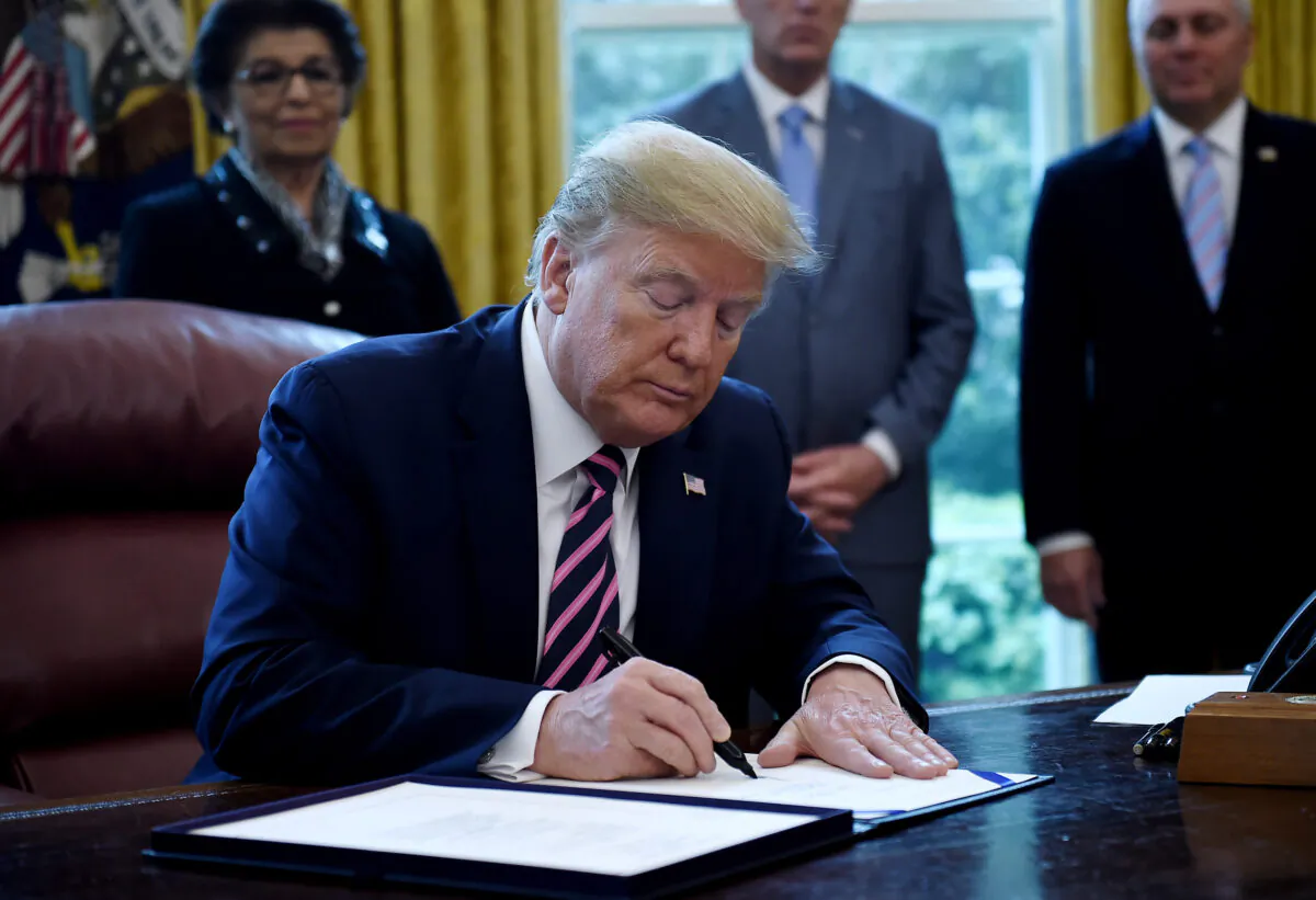 President Donald Trump signs the Paycheck Protection Program and Health Care Enhancement Act in the Oval Office of the White House in Washington, on April 24, 2020. (Olivier Douliery/AFP via Getty Images)