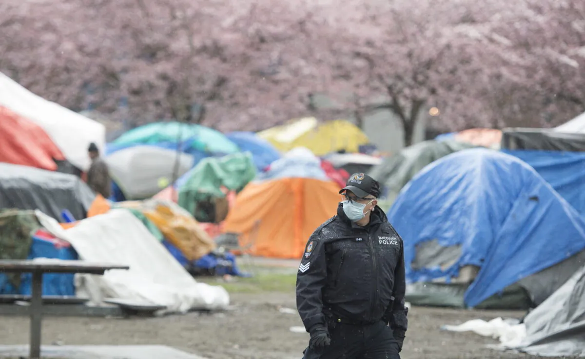 A Vancouver Police officer is seen at Oppenheimer Park in Vancouver's downtown eastside on March 26, 2020. (Jonathan Hayward/The Canadian Press)