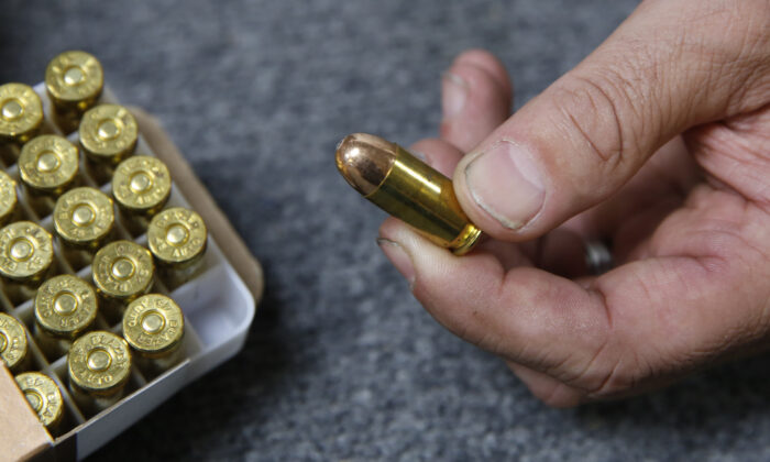 A man holds .45-caliber ammunition at a gun shop in Shingle Springs, California, on June 11, 2019. (Rich Pedroncelli/AP Photo)
