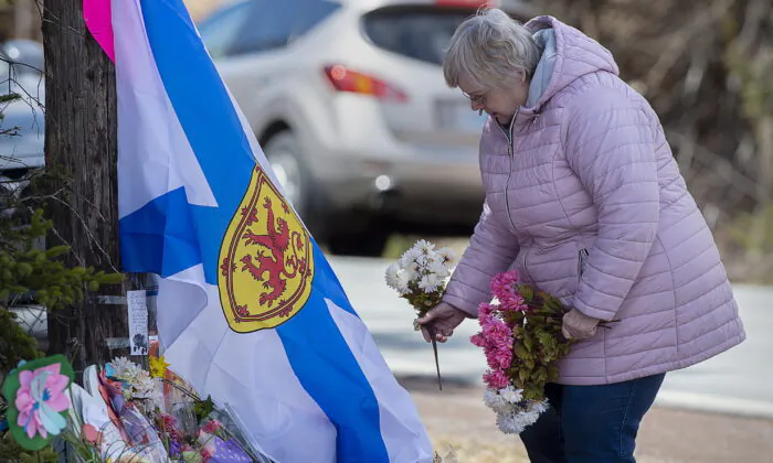 A woman pays her respects to victims of a mass shooting at a roadside memorial in Portapique, Nova Scotia, Canada, on April 23, 2020. (The Canadian Press/via AP/Andrew Vaughan)