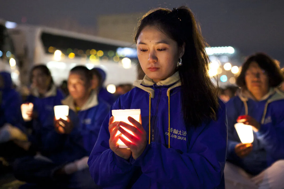 Falun Dafa practitioners hold a candlelight vigil as a peaceful protest near the Chinese Consulate in New York on April 25, 2014, to mark the anniversary of the April 24, 1999 large-scale peaceful protest in Beijing. (Samira Bouaou/Epoch Times)