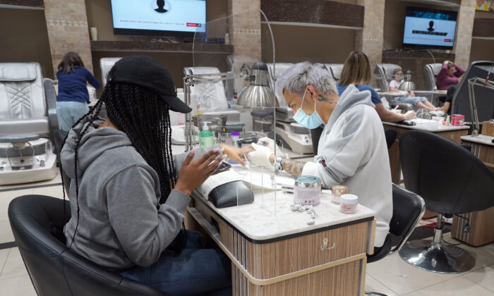 Surin Nguyen (R), wearing protection gear, works on the nails of a customer at Allure Nail Bar in Atlanta, Georgia on April 24, 2020. (TAMI CHAPPELL/AFP via Getty Images)