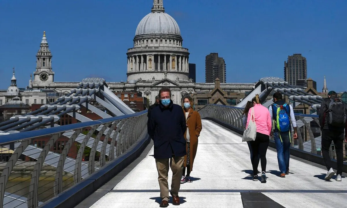 A man walks on Millennium Bridge wearing a protective mask, in London, on April 25, 2020. (Alberto Pezzali/AP Photo) 