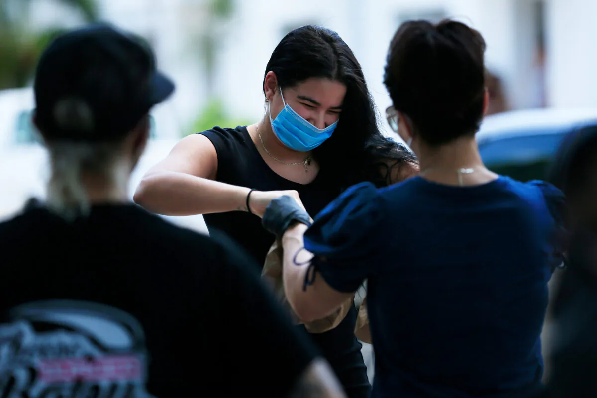 A local resident receives food from the Miami-Dade County Public Schools in Miami Beach, Florida, on April 19, 2020. (Cliff Hawkins/Getty Images)
