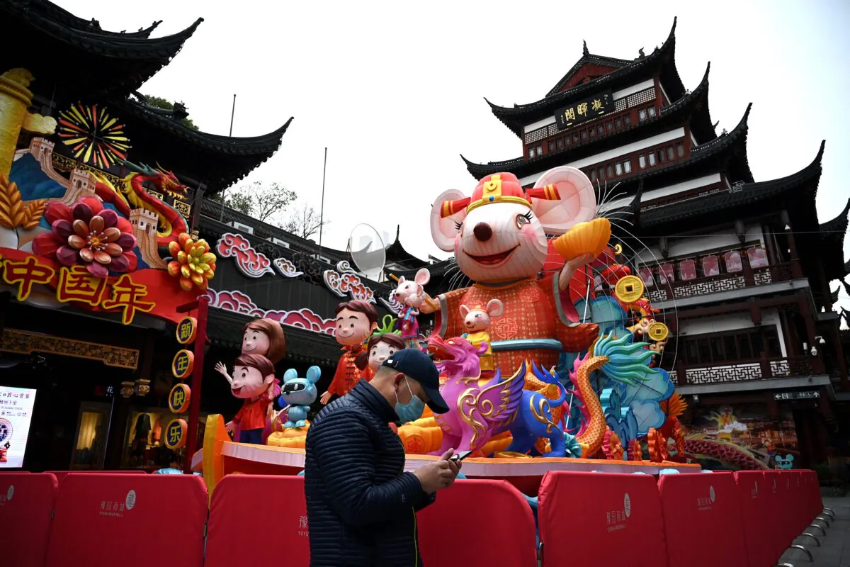 A man wearing a face mask walks past an installation for the recent Lunar New Year of the Rat, at Yu Park in Shanghai on Feb. 6, 2020. (Noel Celis/AFP via Getty Images)