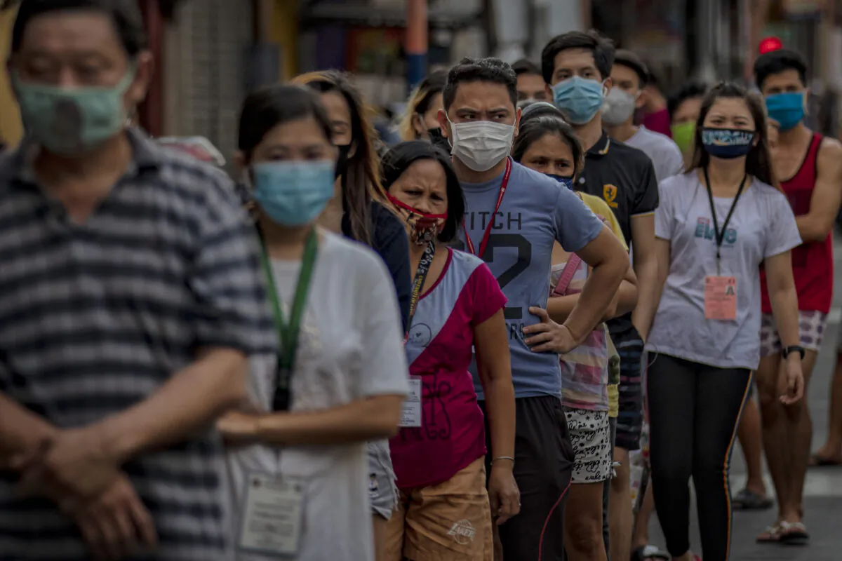 Customers wearing facemasks queue outside a grocery in Manila, Philippines, on April 23, 2020. (Ezra Acayan/Getty Images)