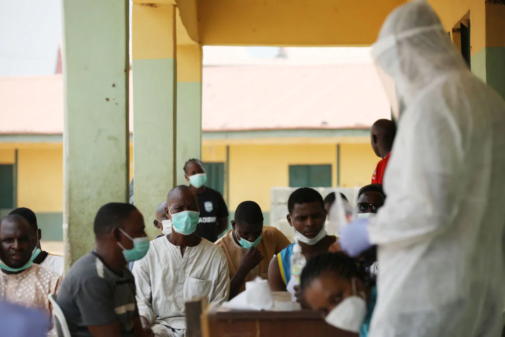 People wait as health workers prepare to take samples during a community CCP virus testing campaign in Abuja, Nigeria, on April 15, 2020. (Kola Sulaimon/AFP via Getty Images)