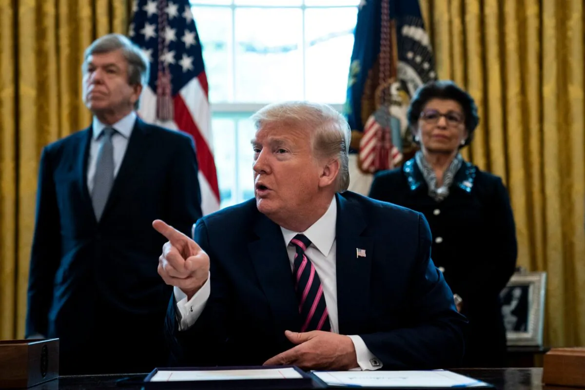 President Donald Trump participates in a signing ceremony for H.R.266, the Paycheck Protection Program and Health Care Enhancement Act, with members of his administration and Republican lawmakers in the Oval Office of the White House in Washington, on April 24, 2020.  (Anna Moneymaker/The New York Times/Pool/Getty Images)
