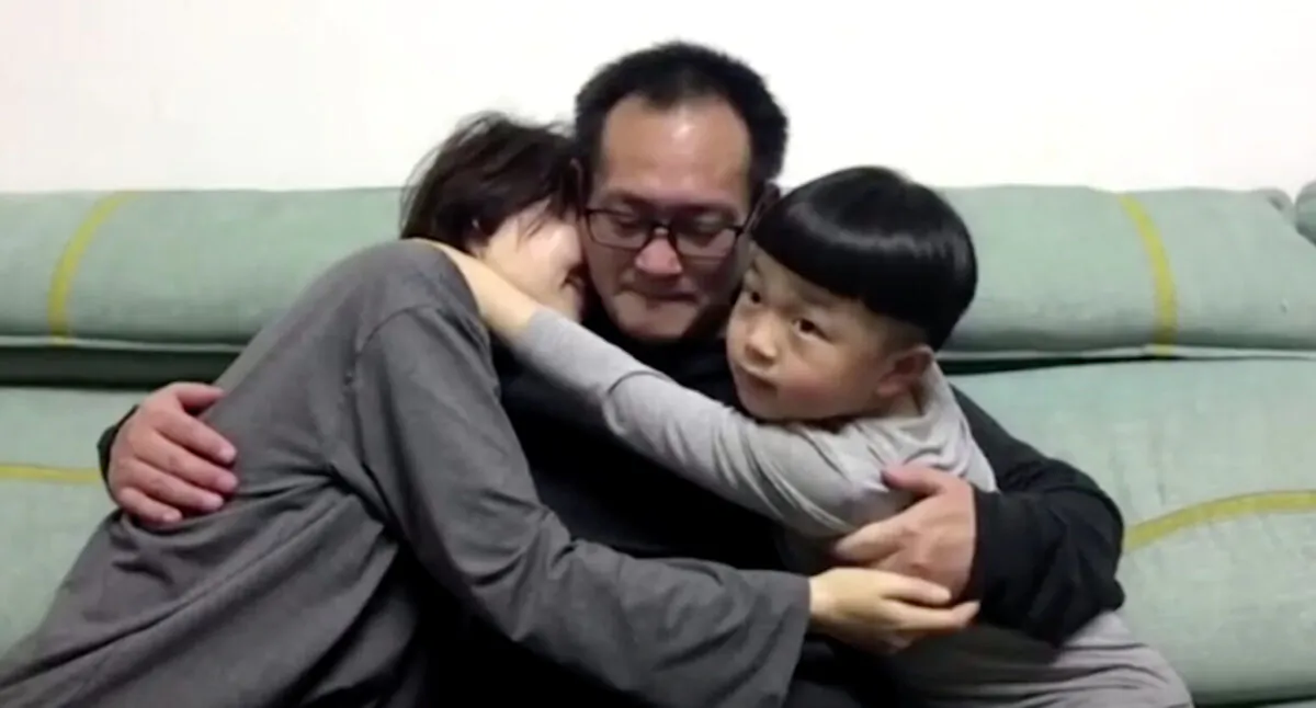 Wang Quanzhang embraces his wife and son at their home in Beijing, on April 27, 2020. (Screenshot via Reuters)
