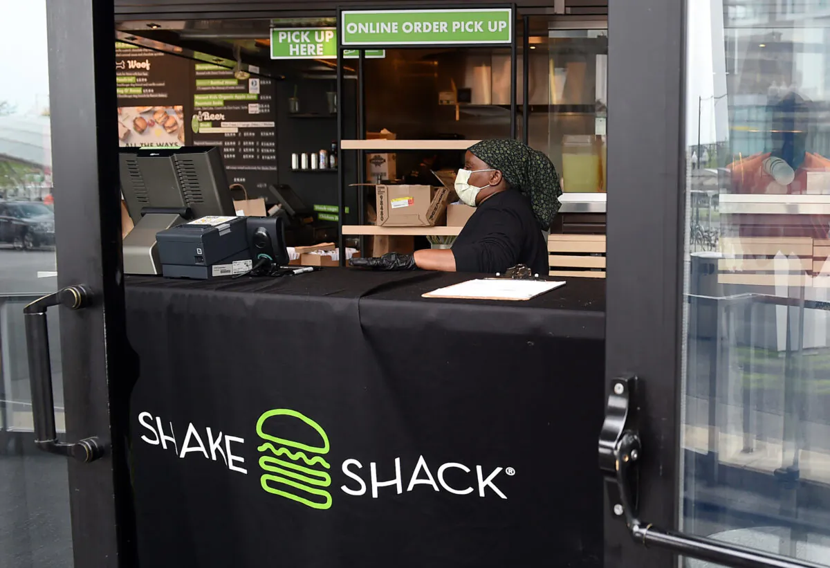 A Shake Shack employee wears a masks as she prepares food orders for pickup during the Coronavirus pandemic in Arlington, Virginia, on April 20, 2020. (OLIVIER DOULIERY/AFP via Getty Images)