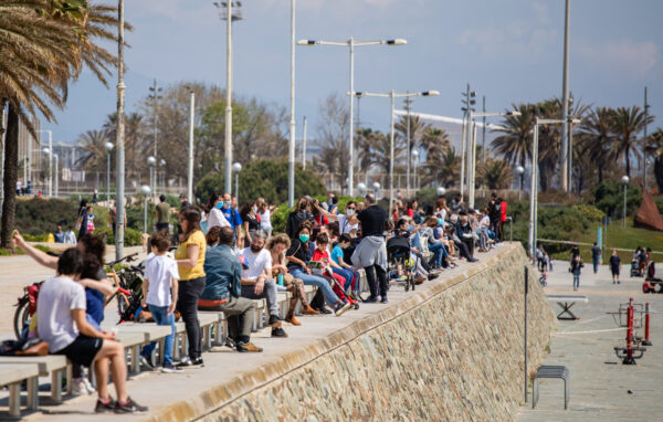 Families with their children sit in a boulevard