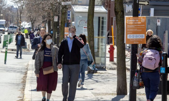 Pedestrians wearing protective masks walk along a sidewalk in Montreal on April 28, 2020. (The Canadian Press/Ryan Remiorz)