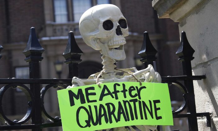 A mock skeleton is attached to the fence as protesters gathered outside Minnesota Gov. Tim Walz' official residence in St. Paul, Minn., on April 17, 2020, to call on him to loosen stay-at-home restrictions imposed across the state because of the coronavirus. (Jim Mone/AP Photo)