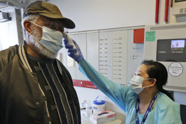 Registered Nurse Janice Tatonetti (R) takes the temperature