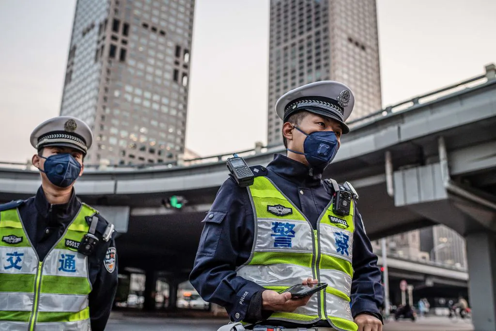 Police officers wearing facemasks patrol on a street in Beijing on April 7, 2020. (Nicolas Asfouri/AFP via Getty Images)
