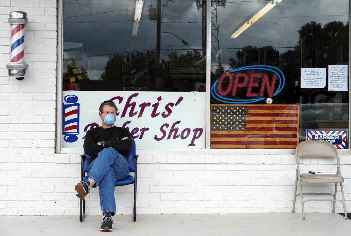 A customer sits outside Chris' Barber Shop as he waits his turn for a haircut in Lilburn, Ga., on April 24, 2020. (Chappell/AFP/Getty Images)