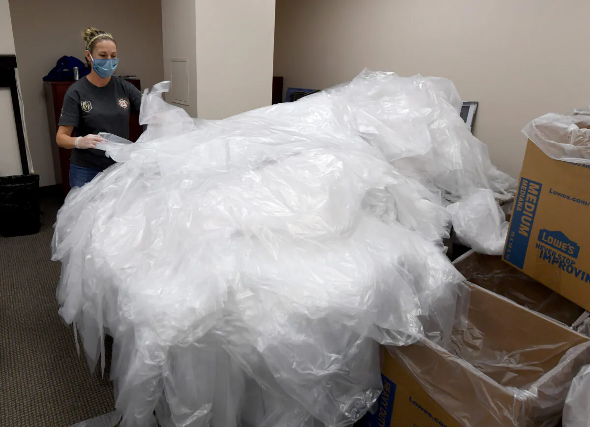 Volunteer Lauren Captain folds and packs disposable protective gowns at Polar Shades Sun Control to help Las Vegas-area health care workers and first responders fighting the coronavirus in Las Vegas on April 14, 2020. (Ethan Miller/Getty Images)