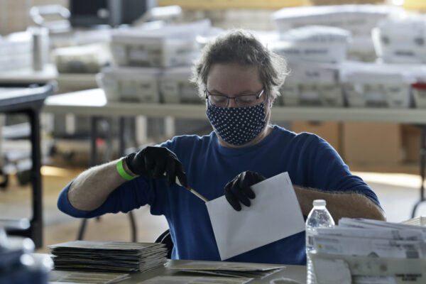 Board of election worker John Carlino opens a ballot