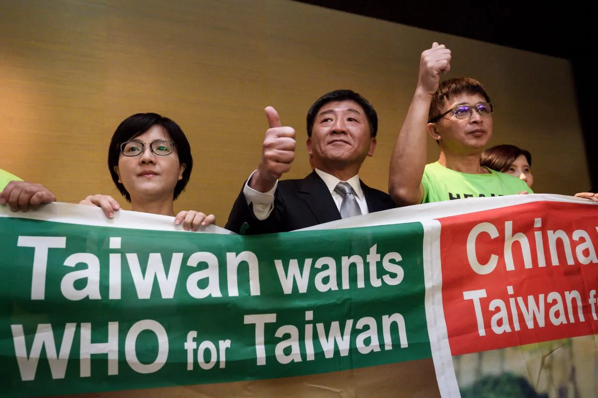 Taiwan's health Minister Chen Shih-chung (C) gives a thumb up as he poses with demonstrators after a press conference on the sideline of the World Health Organization annual Assembly in Geneva, Switzerland, on May 21, 2018. (Fabrice Coffrini /AFP via Getty Images)