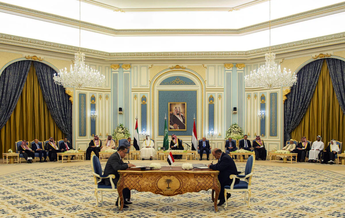 Saudi Royal Palace, Yemeni Southern Transitional Council member and former Aden Governor Nasser al-Khabji, left, and Yemen's deputy Prime Minister Salem al-Khanbashi sign a power-sharing deal in Riyadh, Saudi Arabia on Nov. 5, 2019. (Bandar Aljaloud/Saudi Royal Palace via AP)