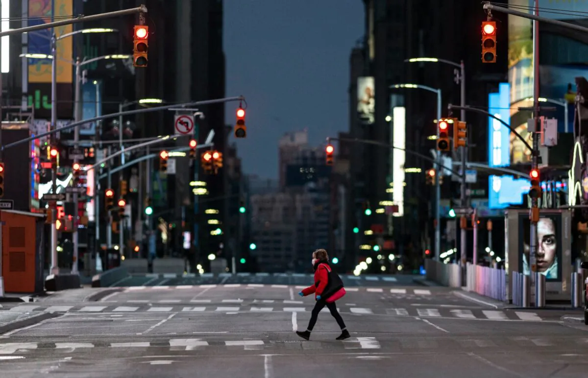 A woman walks through an almost-deserted Times Square in the early morning hours in New York City on April 23, 2020. (Johannes Eisele/AFP via Getty Images)
