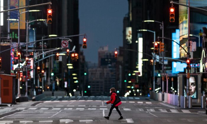 A woman walks through an almost-deserted Times Square in the early morning hours in New York City on April 23, 2020. (Johannes Eisele/AFP via Getty Images)