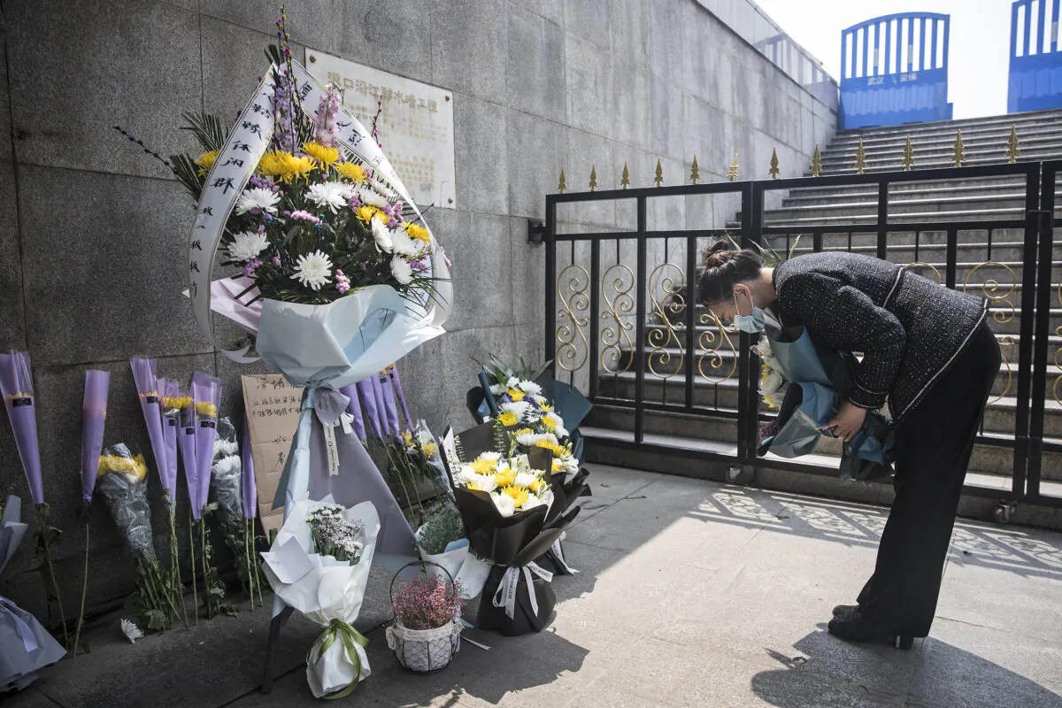 A resident presents flowers during a silent tribute to martyrs who died in the fight against the novel coronavirus disease (COVID-19) outbreak and compatriots who died of the disease in Wuhan, Hubei Province, China, on April 4,2020. (Getty Images)