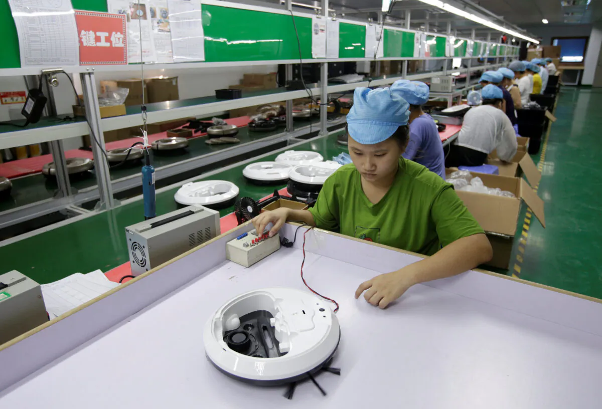 An employee works on the production line of a robot vacuum cleaner factory of Matsutek in Shenzhen, China, on Aug. 9, 2019. (Jason Lee/Reuters)