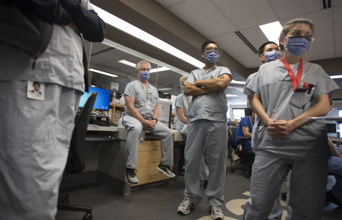 Dr. Del Dorscheid (C) takes part in board rounds in the COVID-19 intensive care unit at St. Paul's hospital in downtown Vancouver on April 21, 2020. (Jonathan Hayward/The Canadian Press)