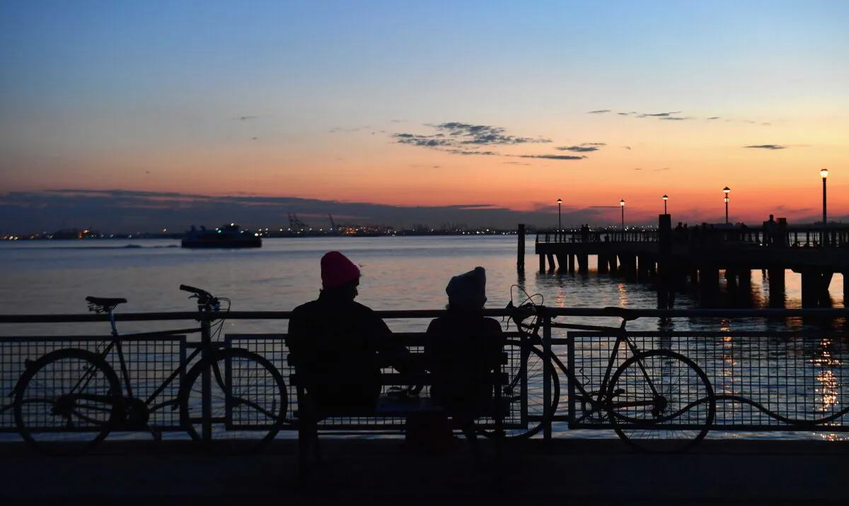 A couple watches the sunset amid the novel coronavirus pandemic in New York City on April 28, 2020. New York, which has ground to a halt to stop the coronavirus pandemic, may start reopening manufacturing and construction after May 15, Governor Andrew Cuomo said on April 26. (Angela Weiss/AFP via Getty Images)
