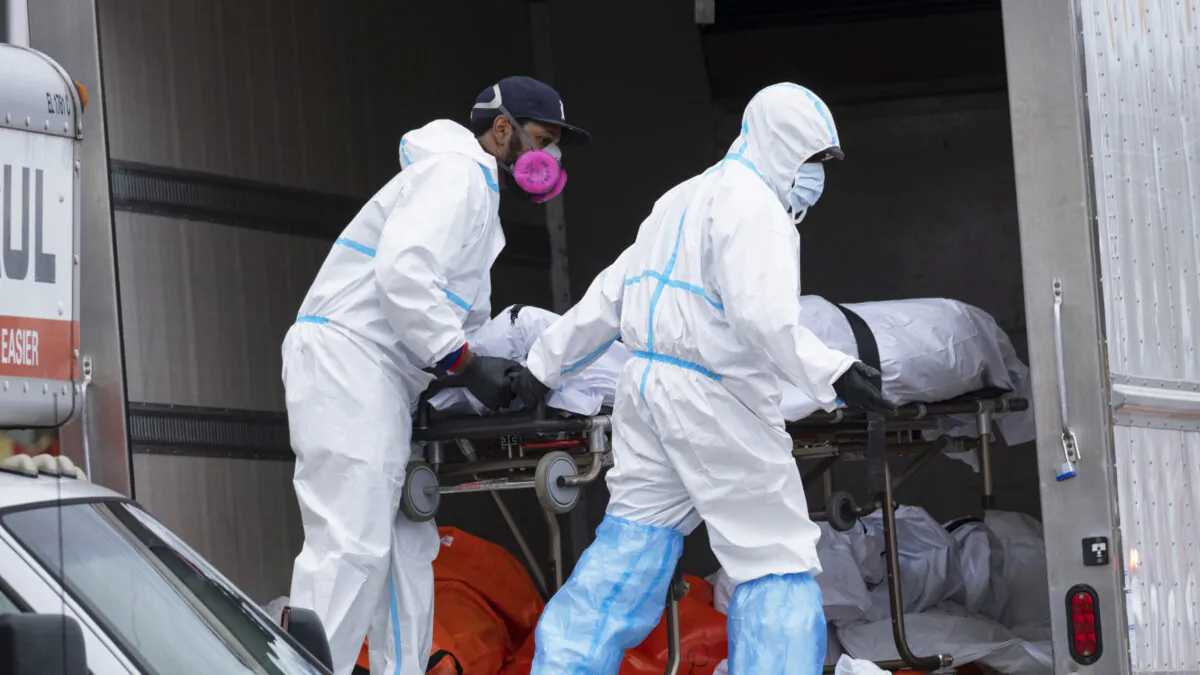 Workers move bodies to a refrigerated truck from the Andrew T. Cleckley Funeral Home in the Brooklyn borough of New York City on April 29, 2020. (Craig Ruttle/AP)
